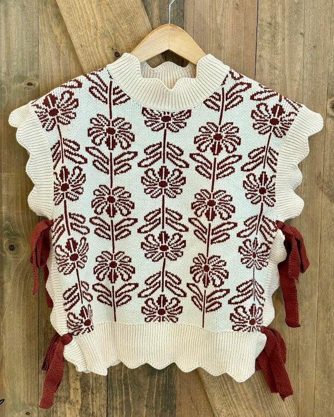 White sweater with brown floral pattern and bows on the side