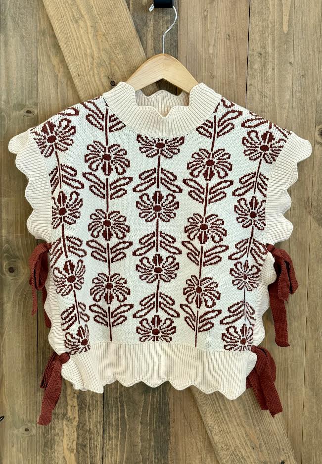 White sweater with brown floral pattern and bows on the side