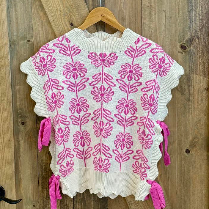 White sweater with pink floral pattern and bows on the side