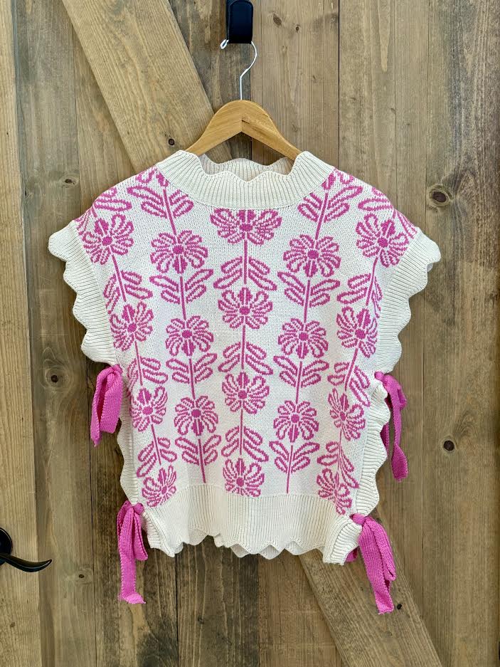 White sweater with pink floral pattern and bows on the side