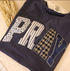 Navy blue t-shirt with 'PRAY' text in various patterns like patchwork.